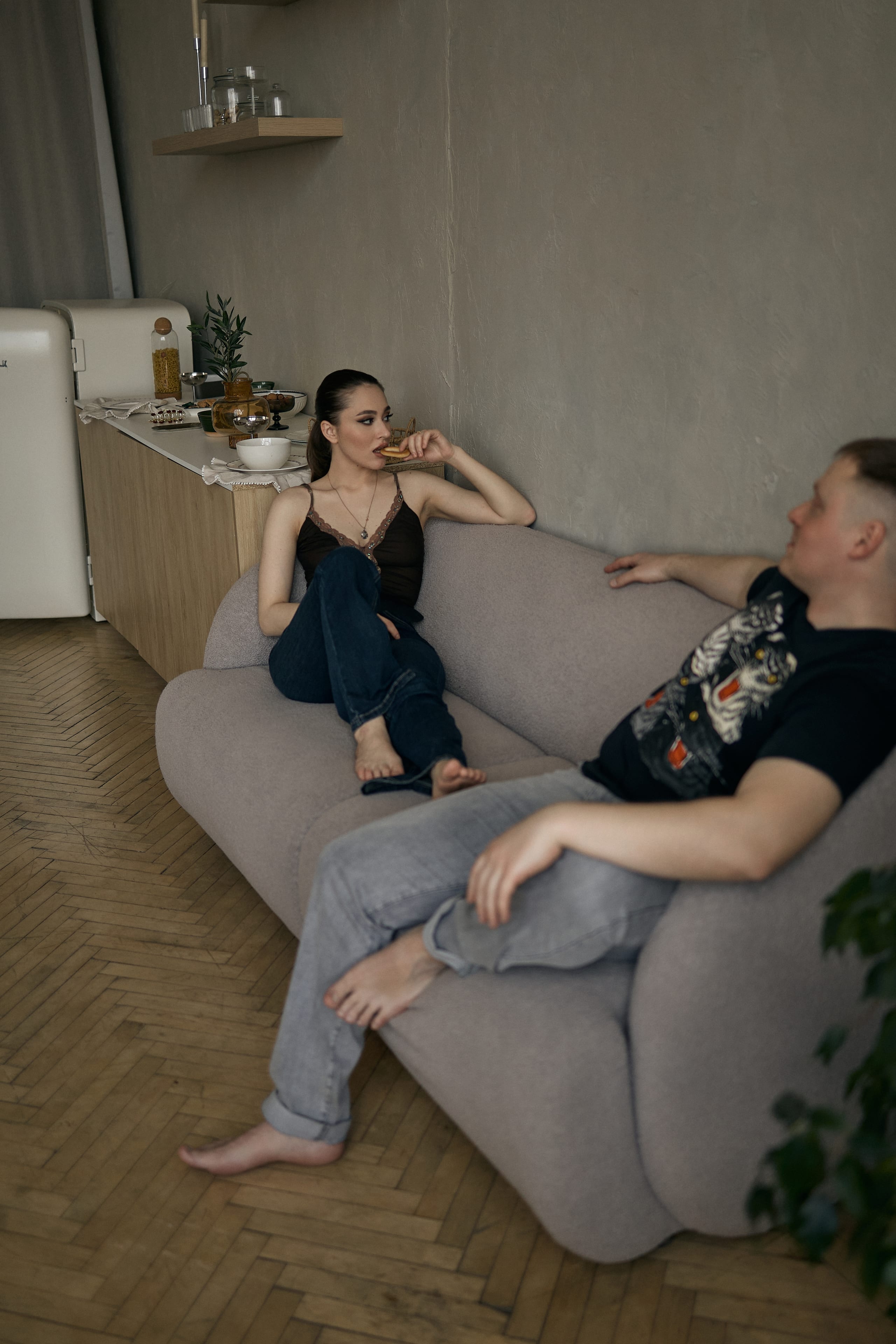 Пара на диване, женщина полулежит, мужчина сидит